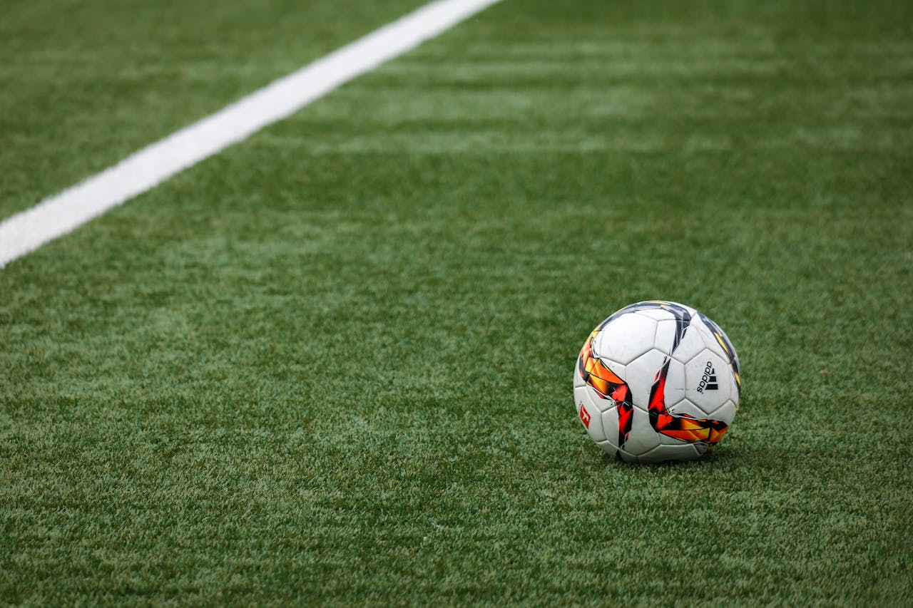 Crafting Captivating Headlines: Your awesome post title goes here A vibrant soccer ball resting on a pristine grass field beside a white sideline.