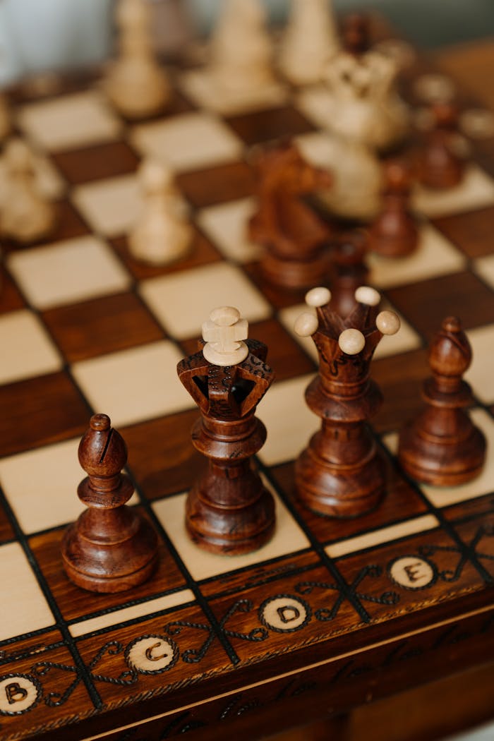 Mastering the First Impression: Your intriguing post title goes here Close-up view of intricately carved wooden chess pieces on a chessboard, showcasing strategy and craftsmanship.